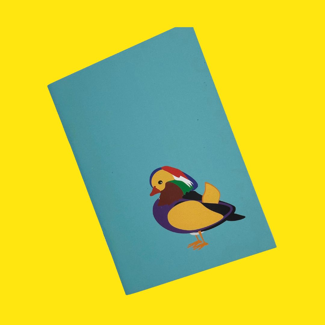 Mandarin Duck teal pocket sized notebook with 36 plain pages printed with plant based inks on recycled paper at a local carbon neutral printers