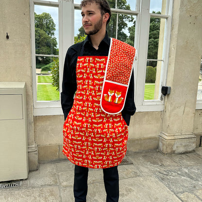 Fox apron in organic cotton shown worn by male model with matching oven gloves